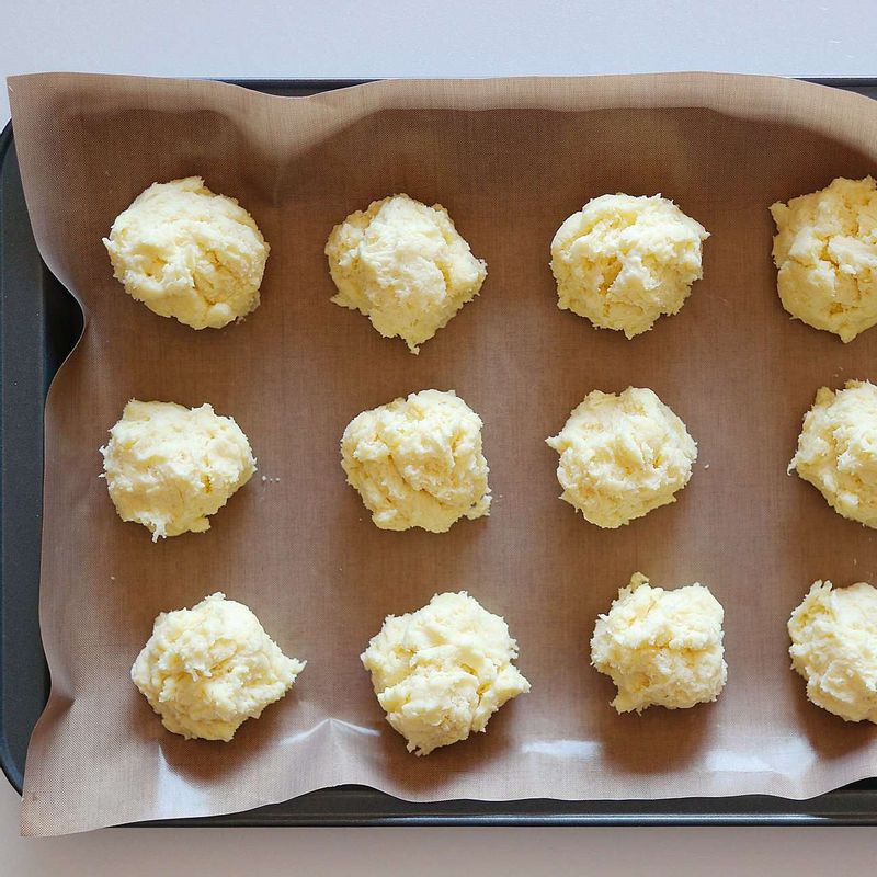 팬 위에 유산지를 깔고 반죽을 적당한 크기로 떼어 올려주세요.