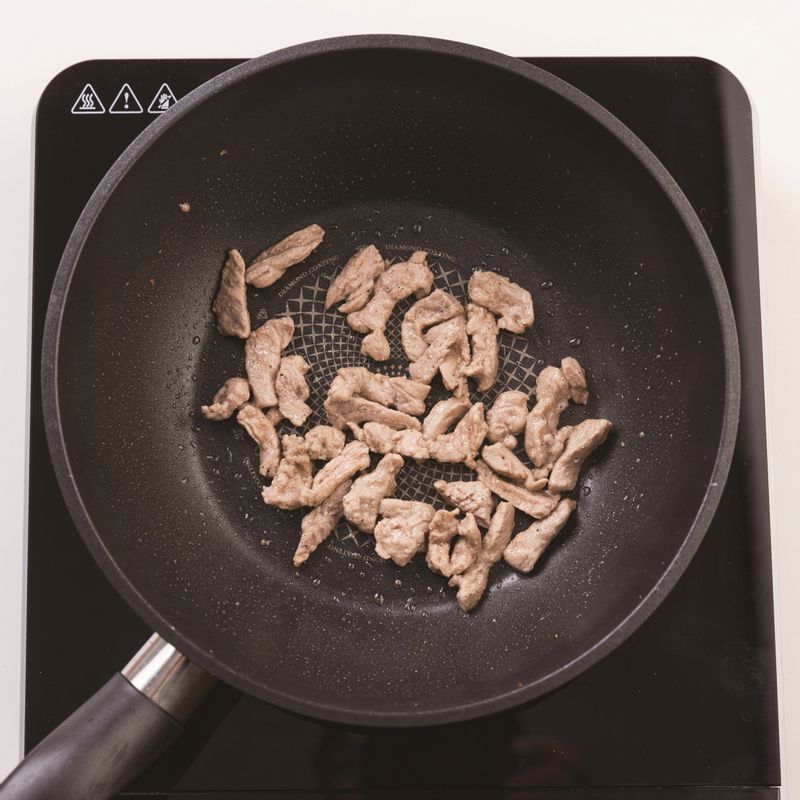 달군 팬에 카놀라유 1술을 두른 뒤 채 썬 양파와 청피망, 홍피망, 소금을 넣고 중불에서 3분간 볶아주세요. 그 뒤 달군 팬에 카놀라유 1술을 두른 뒤 10분간 밑간한 돼지고기를 넣고 중약불에서 3~4분 볶아주세요.
