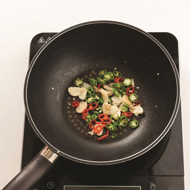 달군 팬에 올리브유를 두르고 슬라이스한 마늘, 어슷하게 썬 홍고추와 청양고추를 넣고 중불에서 2분간 볶아주세요.