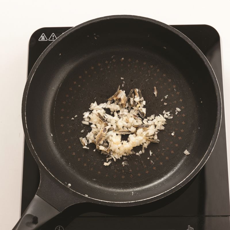 달군 팬에 카놀라유를 두른 뒤 중불에서 다진 양파를 넣고 볶다가 갈색이 되면 손질한 마른 멸치를 넣어 볶아주세요.
*Tip. 멸치를 볶아서 쓰면 비린 맛을 줄일 수 있어요.