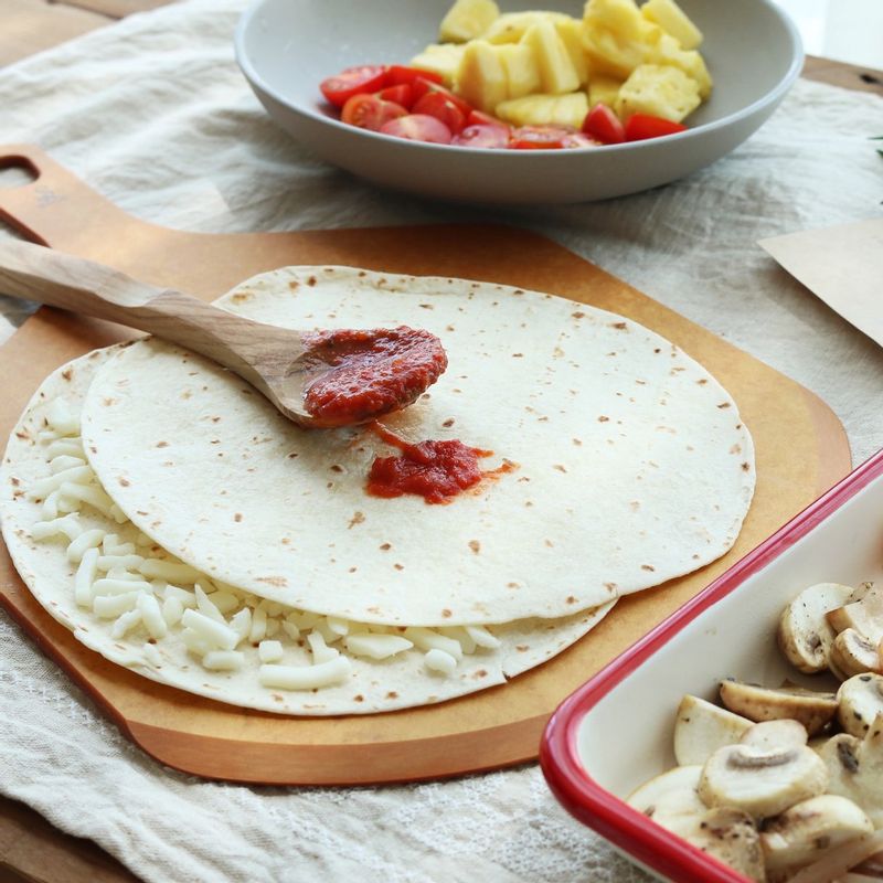 토르티야에 피자치즈를 골고루 뿌리고 다시 토르티야 한 장을 겹쳐 올립니다. 토마토소스를 고르게 펴 바른 후 양파를 깔고 피자치즈를 한 번 더 뿌려주세요.