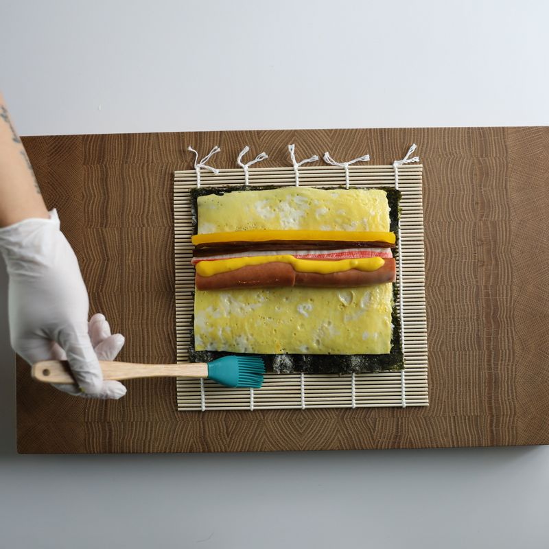 김 끝부분에 물을 바르고 재료가 흐트러지지 않게 돌돌 말아주세요.
*Tip. 밥알로 붙여도 되지만 물을 묻히면 김이 더 잘 붙어요!