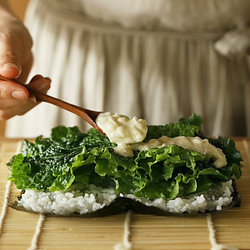 김발에 김을 올리고 밥을 고르게 편 후 상추를 깔고 소스를 고르게 얹어주세요.