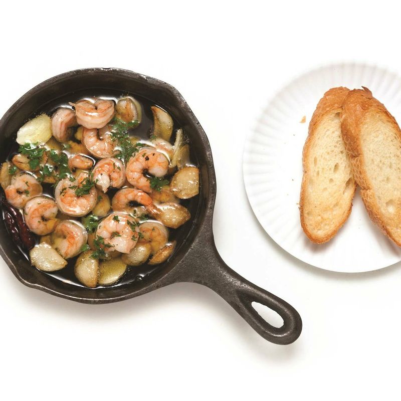 마늘이 노릇해지면 칵테일새우를 넣고 끓여주세요. 새우가 붉게 변하면 파슬리가루를 뿌리고 빵을 곁들여 맛있게 즐기세요.