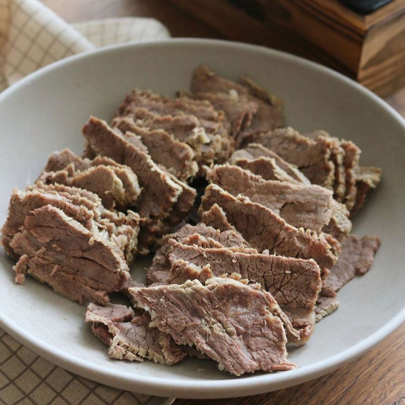 냄비에 부추와 팽이를 돌려 담고, 썰어놓은 고기를 올려주세요.