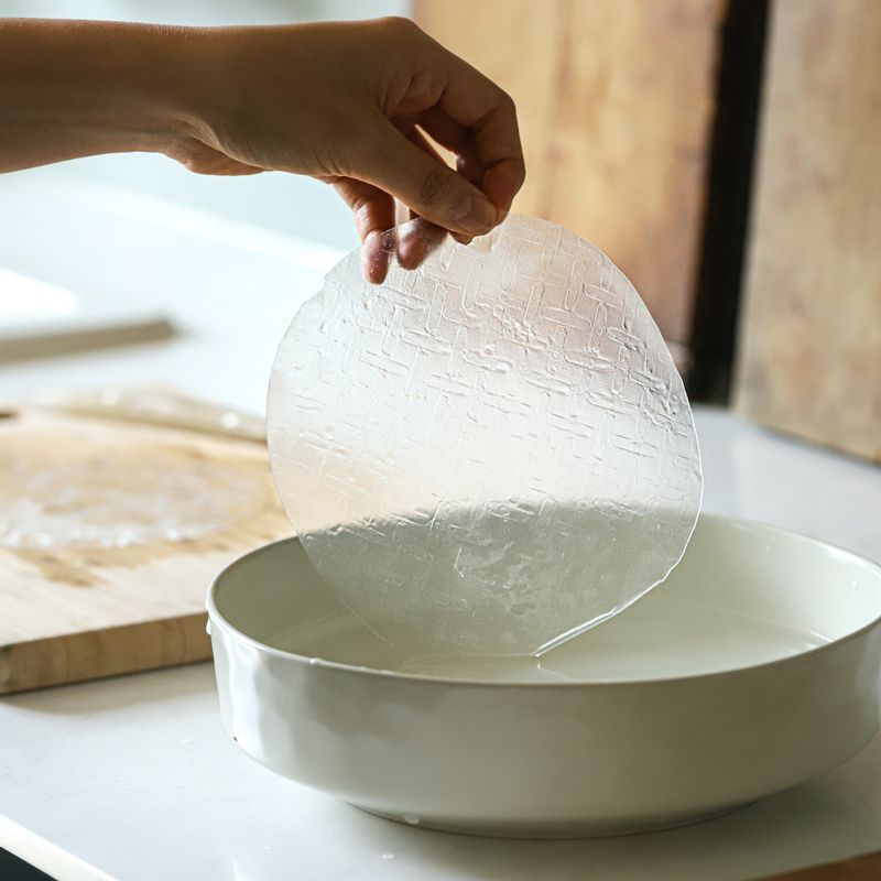 라이스 페이퍼를 따뜻한 물에 담갔다가 건져 세 장을 겹쳐 돌돌 말아주세요. 같은 방법으로 세 장을 깐 후 4등분으로 자른 치즈를 끝에 깔고 돌돌 말아 반으로 잘라주세요.