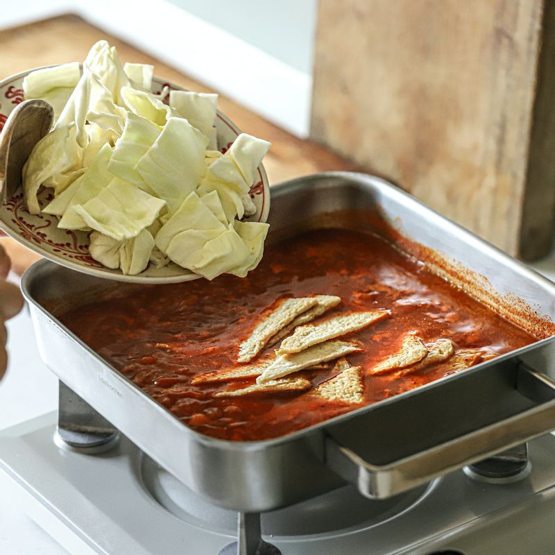 양배추를 넣어 1분 정도 끓인 후 말아 둔 라이스 페이퍼와 대파를 넣어 주세요. 국물의 농도를 맞춘 후 불을 꺼주세요.