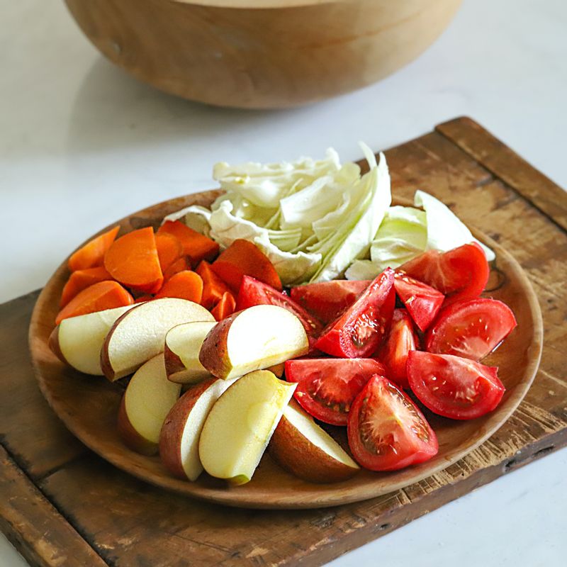 토마토는 꼭지를 뗀 후 적당한 크기로 자르고 사과는 씨 부분을 제거한 후 적당한 크기로 잘라주세요. 당근과 양배추도 적당한 크기로 잘라주세요.