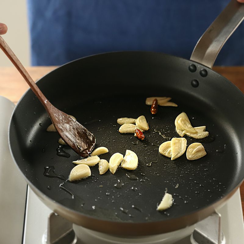 팬에 기름을 약간 두르고 편 썬 마늘과 페퍼론치노를 넣고 약불에서 볶다가 대파를 넣어 노릇하게 볶은 후 접시에 덜어주세요.