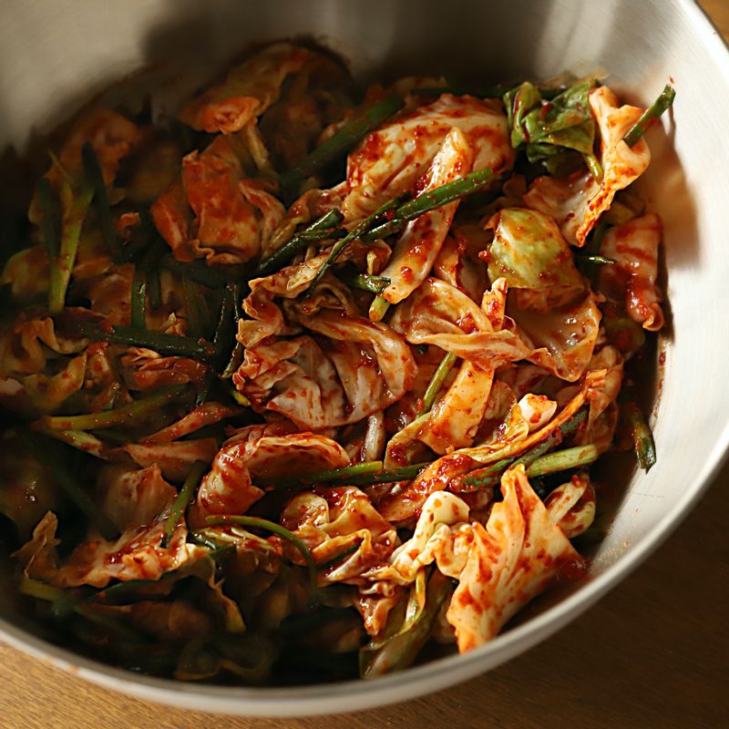 절인 양배추에 쪽파와 김치 양념을 넣어 버무려주세요.
(tip. 절인 양배추에서 나온 물만 버린 후 헹구지 말고 사용해 주세요.)