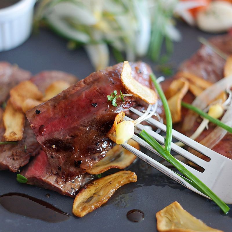 쇠고기를 한입 크기로 잘라 그릇에 담고 구운 마늘과 소스를 얹어주세요. 채 썬 양파, 달래를 섞어 곁들여주면 좋아요.