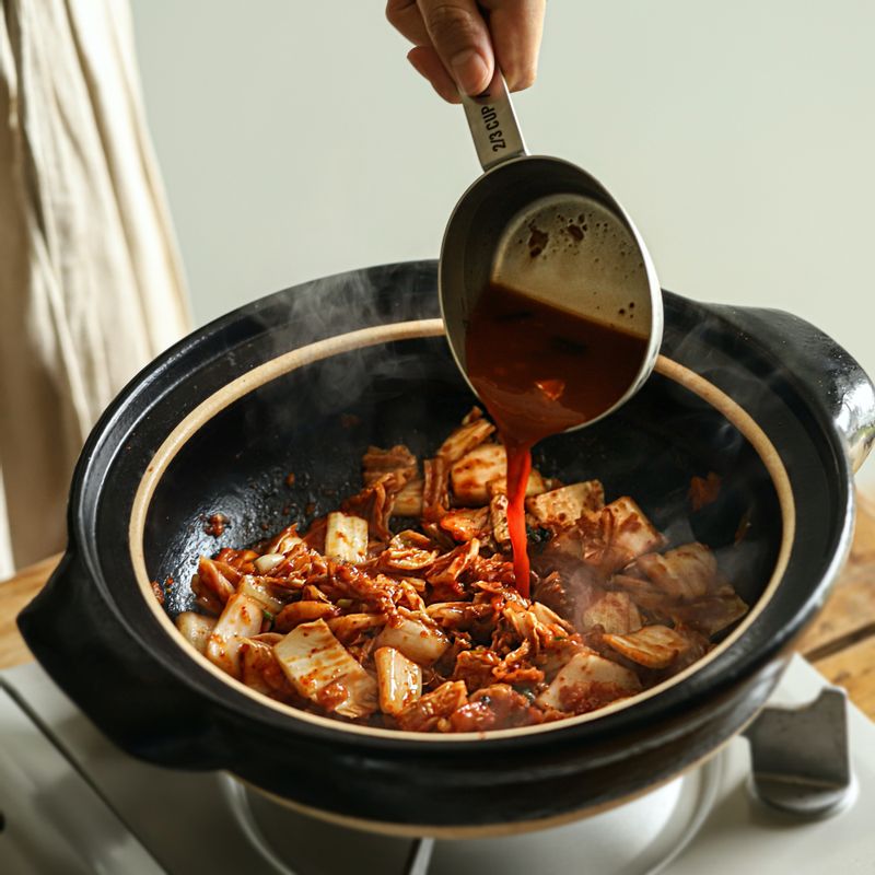 냄비에 약간의 참기름을 두르고 김치와 김칫국물을 넣어 볶다가 김치가 투명해지면 멸치 다시마 육수와 무를 넣어 끓여주세요.