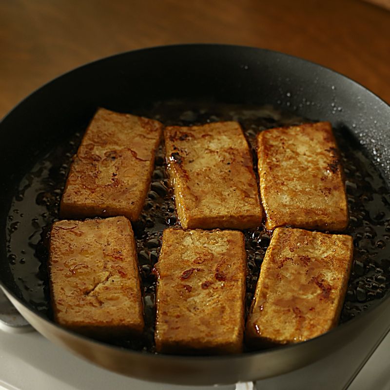 달군 팬에 들기름을 두른 후 두부를 넣고 앞뒤로 노릇하게 굽다가 양념 재료를 넣고 국물이 자작할 때까지 졸여주세요.
