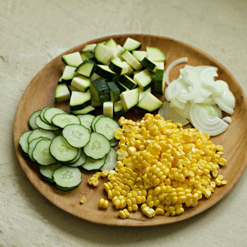 오이와 양파는 얇게 슬라이스 해주세요. 초당 옥수수는 알맹이만 칼로 잘라 주세요. 주키니는 먹기 좋게 썰어주세요.