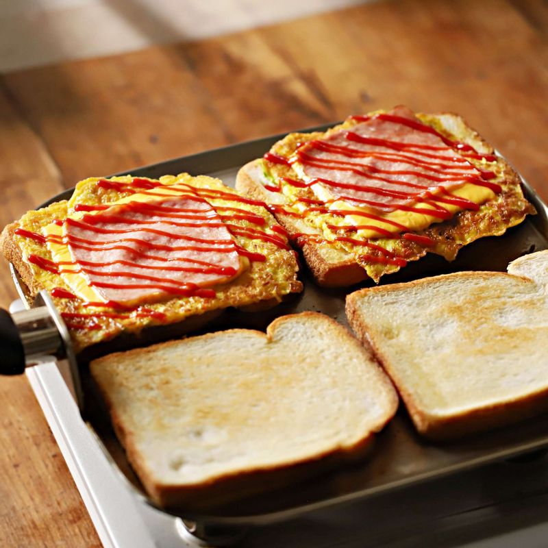 식빵에 사과잼을 바른 후 달걀-체더슬라이스치즈-슬라이스 햄-케찹을 바른 후 빵으로 덮어주세요.