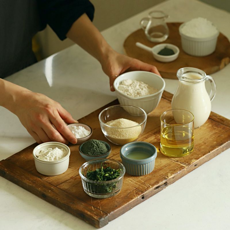 비건 쑥 머핀을 위한 재료 이미지로 두유,포도씨 오일,황설탕,레몬즙,통밀가루 등으로 구성 되어있습니다.