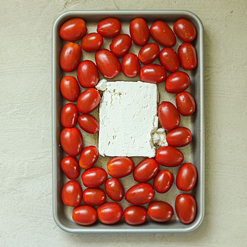 오븐 팬에 페타치즈와 방울토마토를 담고 소금과 후추 다진 마늘, 올리브오일, 건 바질을 넣어주세요. 생바질은 잘게 다져주세요.