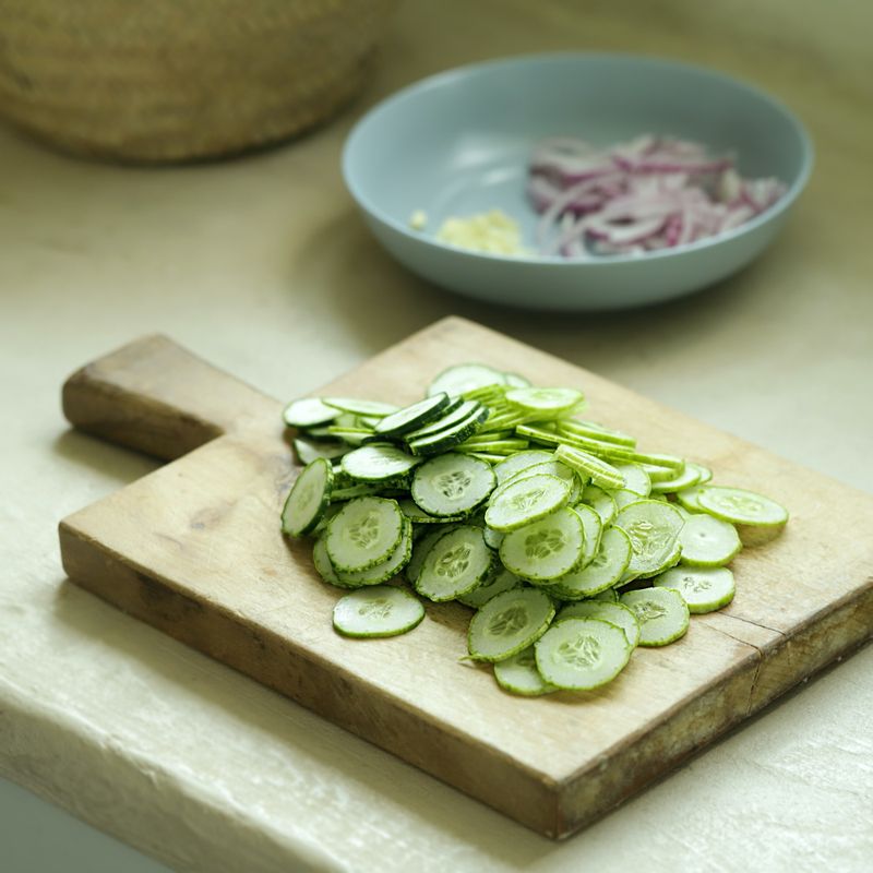 적양파는 얇게 썰어주세요. 오이는 얇게 슬라이스 해주세요. 마늘은 다져주세요.