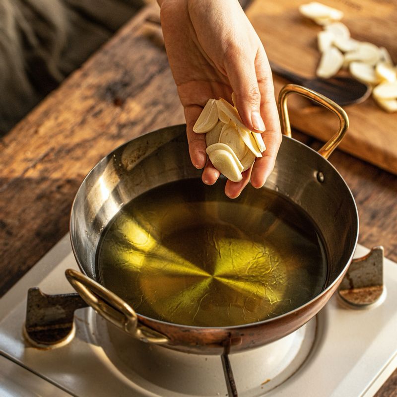 팬에 올리브오일을 붓고 살짝 데워져서 기포가 올라오면 마늘 편을 넣어 1분 정도 끓여주세요.