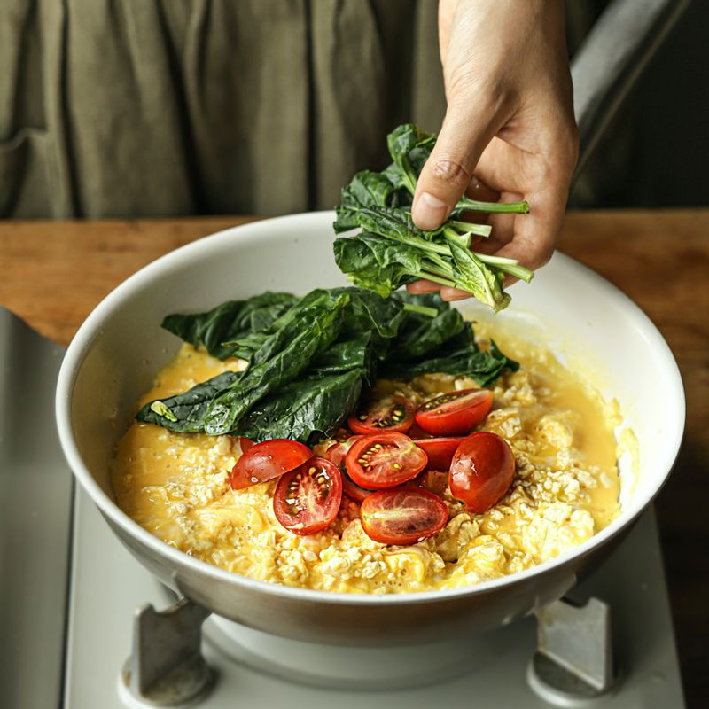 달걀이 반 정도 익으면 토마토와 시금치를 넣어 골고루 섞어가며 볶아주세요.