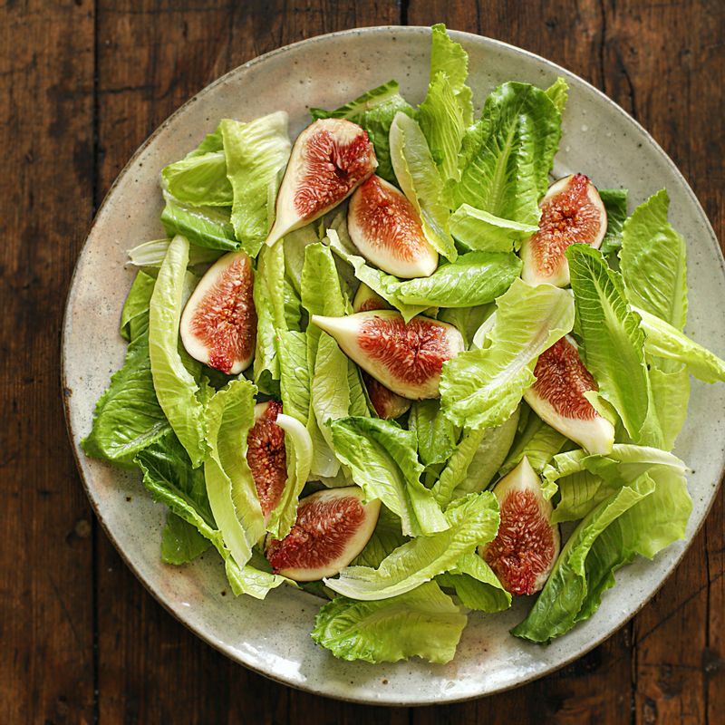 그릇에 로메인 상추, 무화과, 프로슈토 햄, 치즈를 담아주세요.