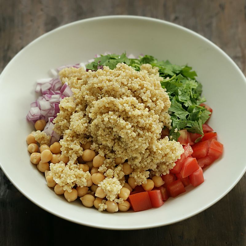볼에 토마토와 적양파, 고수를 넣고 삶은 병아리콩, 퀴노아를 넣어주세요.
(tip. 병아리콩은 캔을 사용하시거나 6시간 정도 불린 후 15분간 삶아 사용해주세요)