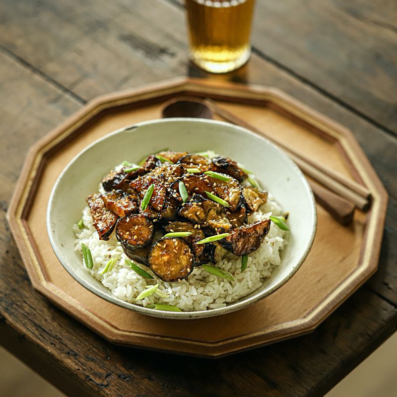 그릇에 밥을 담은 후 가지를 담아주세요. 쪽파와 깨를 뿌려 맛있게 즐겨주세요.