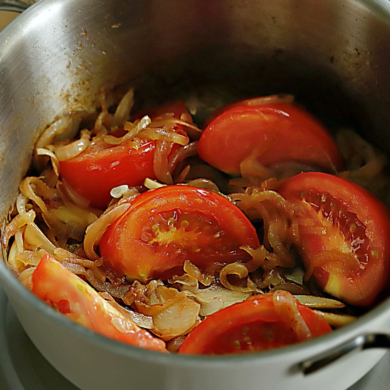 달군 냄비에 기름을 두르고 채를 썬 양파와 마늘를 넣어 볶다가 양파가 노릇해지면 토마토를 넣고 볶아주세요.