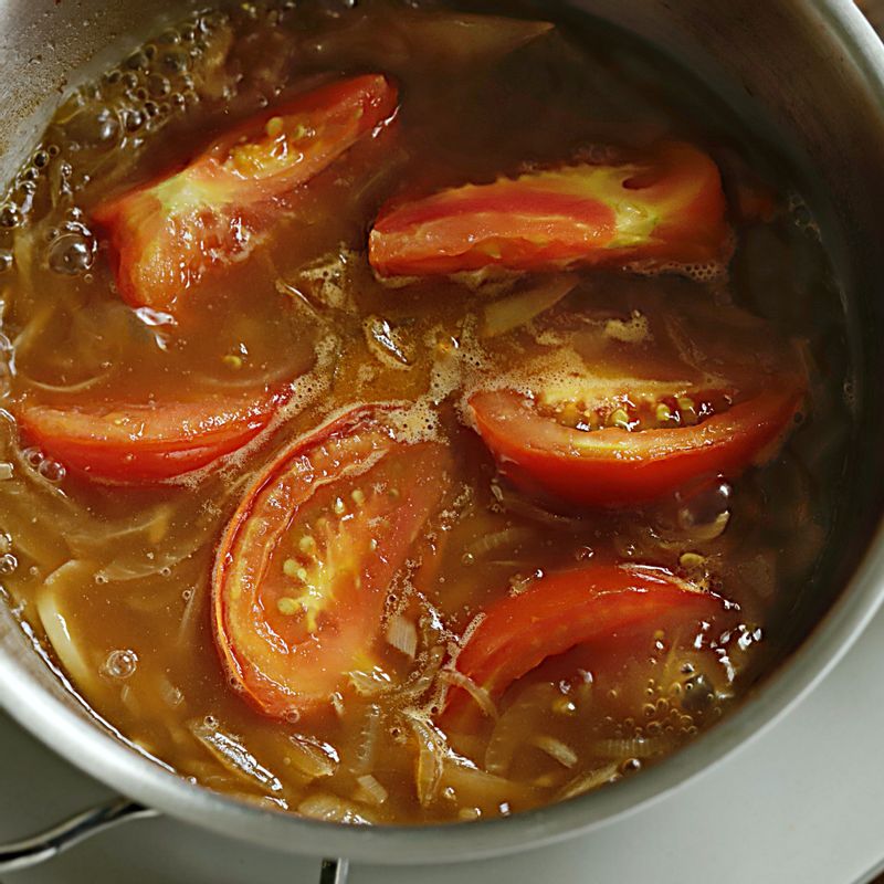 토마토가 익으면 물을 붓고 끓이다가 카레 가루를 넣고 약불에서 저어가며 끓여주세요.