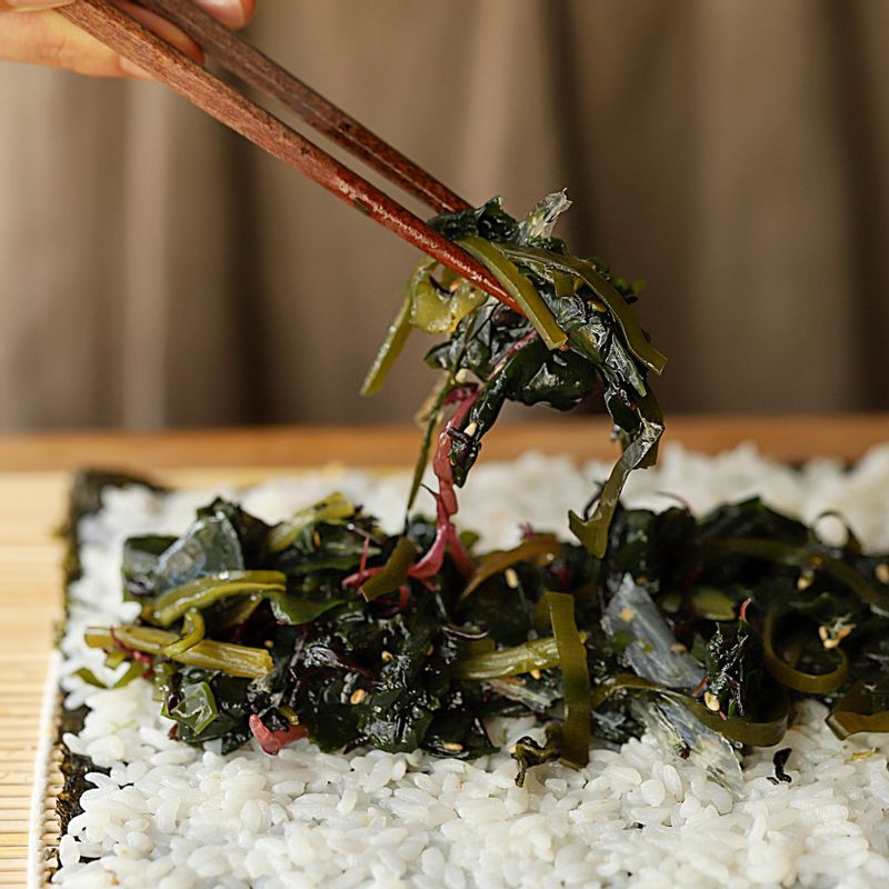 김에 밥을 얇게 펼치고 해초와 두부, 당근, 오이를 넣어 김밥을 말아주세요.