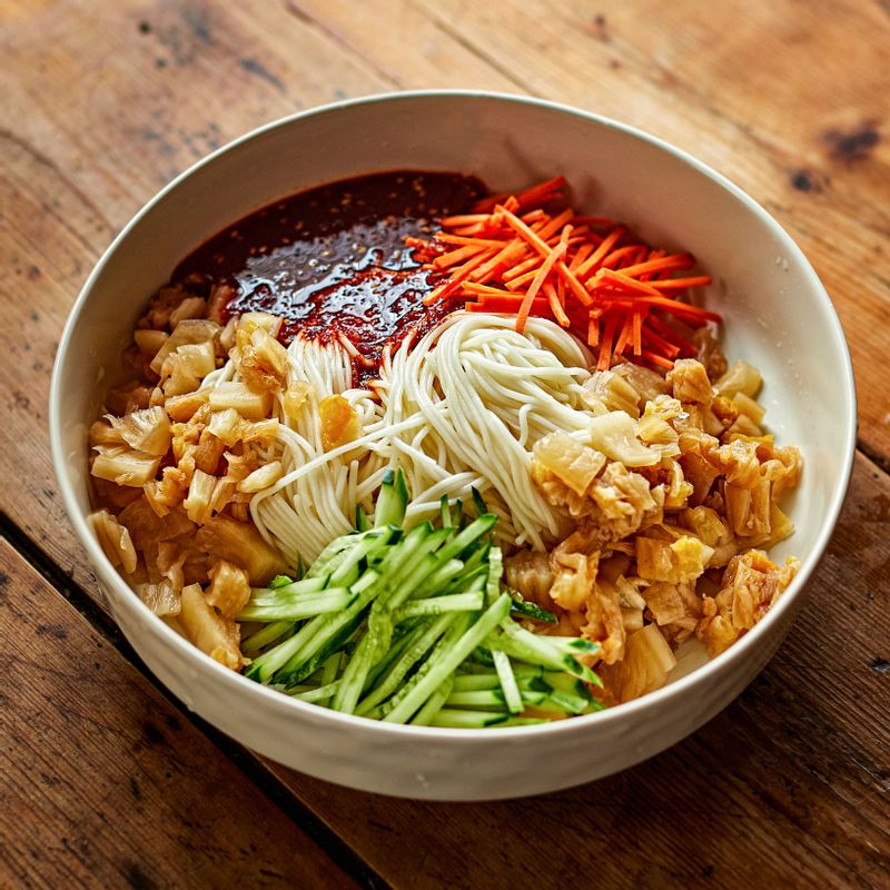 볼에 중면과 묵은지, 썰어 둔 야채와 양념을 넣어 고루 버무려주세요.