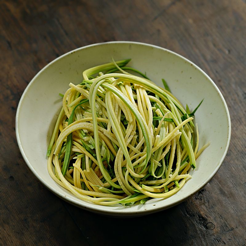 애호박은 채칼을 이용해 길고 얇게 썰어주세요. 양파는 얇게 채 썰어주세요.