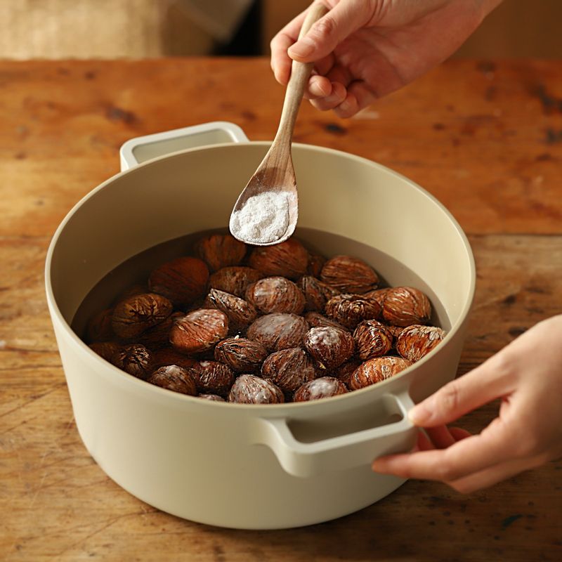 냄비에 밤과 밤이 잠길 정도의 물을 넣은 후 베이킹 소다를 넣어 10시간 정도 동안 담가주세요. 밤 주름 사이에 낀 심지는 이쑤시개로 제거해 주세요.
(베이킹 소다에 담가두면 밤 속껍질(율피)의 쓴맛이 제거돼요)
(불려둔 후 심지를 제거하면 쉽게 제거할 수 있어요)