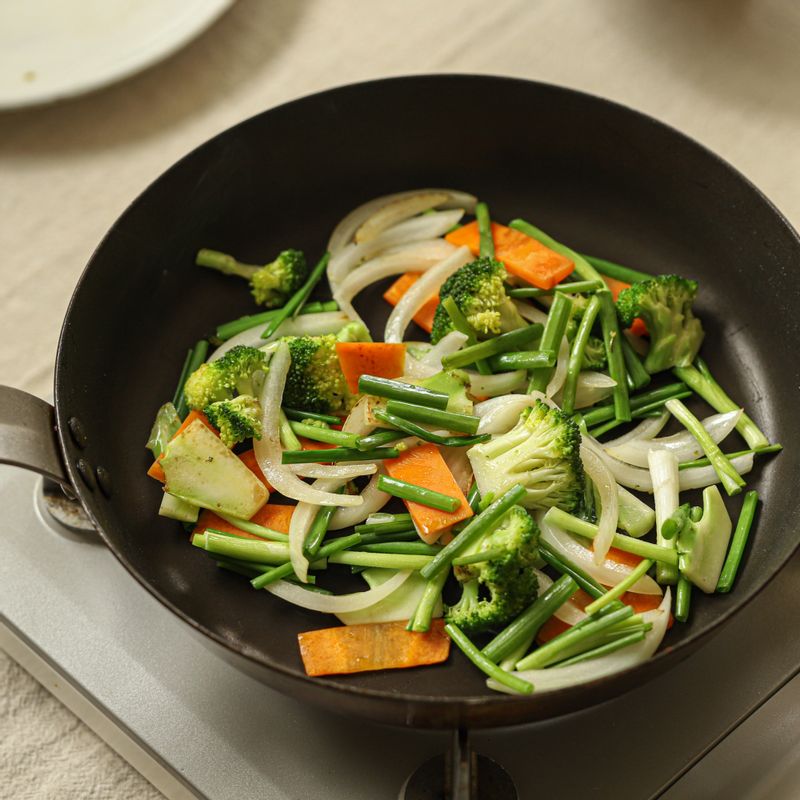 달군 팬에 기름을 두른 후 채소를 넣고 강한 불로 2분간 볶아주세요.