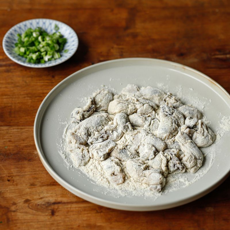 세척한 굴에 밀가루를 얇게 묻혀주세요. 쪽파는 송송 썰어주세요.