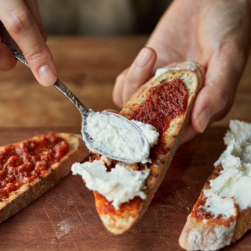 페이스트 위에 섞어둔 치즈를 올리고 선 드라이 토마토와 바질 잎을 올려주세요.