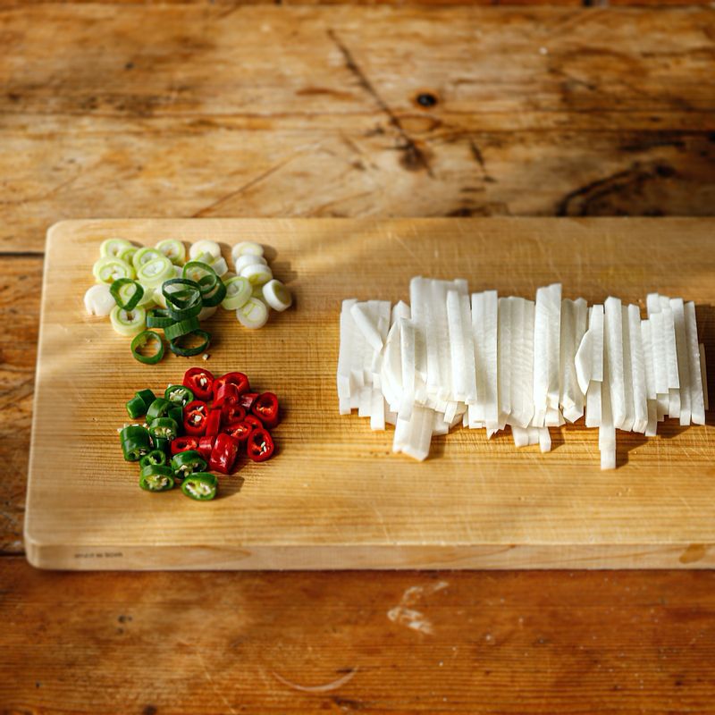 차돌박이는 먹기  좋게 자르고 키친타월에 올려 핏물을 빼주세요. 무는 도톰하게 채 썰고 대파, 홍고추, 청양고추는 송송 썰어주세요. 볼에 양념 재료를 넣어 섞어주세요.