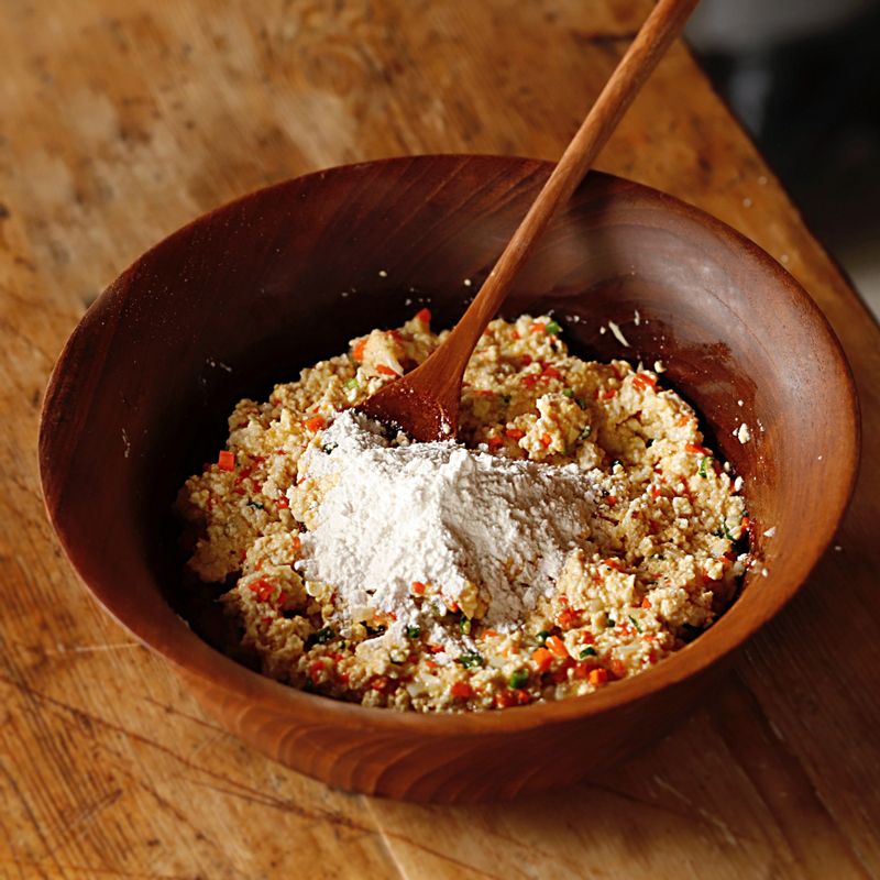 으깬 두부에 다진 채소를 넣고 달걀과 소금, 후추,  찹쌀가루를 넣어 섞어주세요.