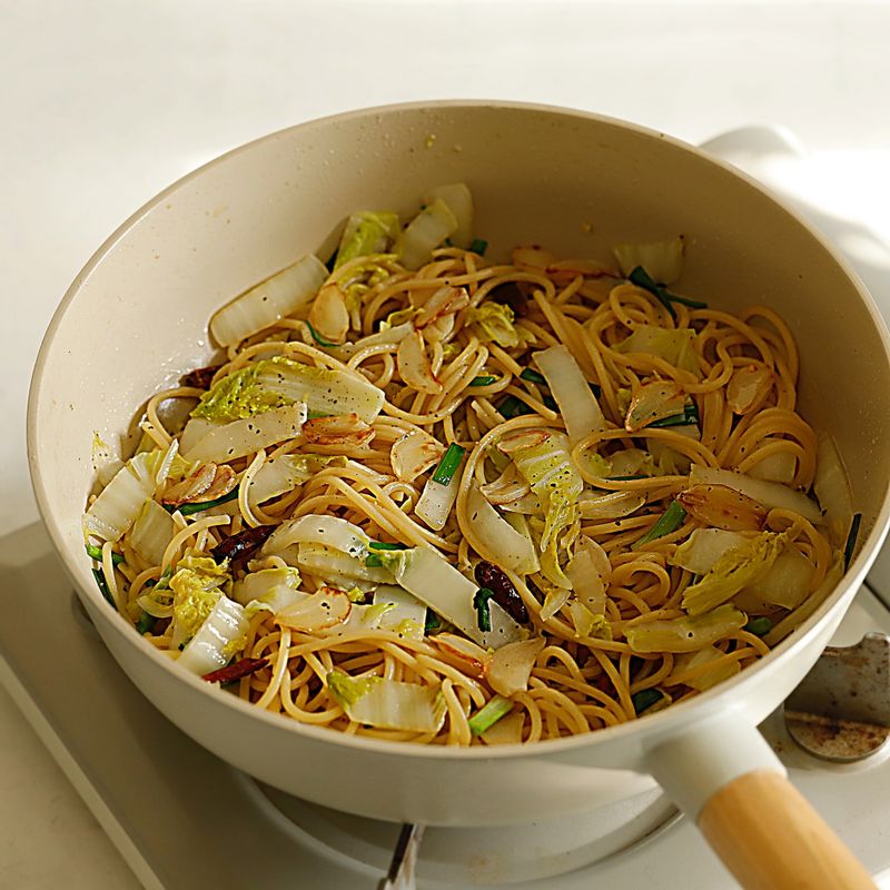 나머지 배추를 넣고 볶다가 면과 면수를 넣고 간장과 후추를 뿌려 1분간 볶아주다가 불을 끄고 쪽파와 들기름을 넣고 골고루 섞어주세요.