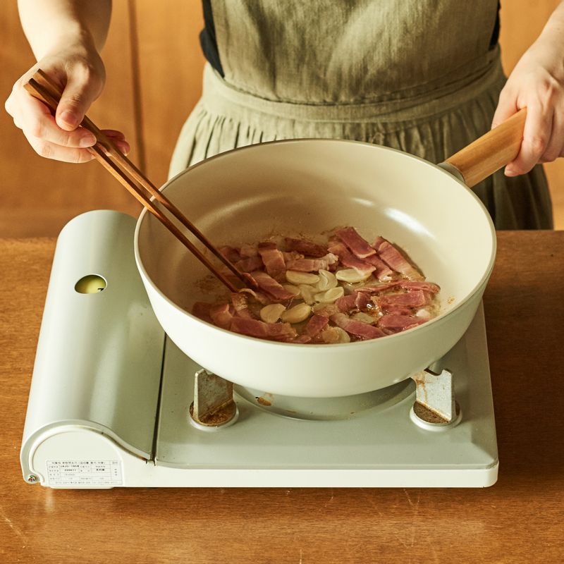 달군 팬에 기름을 두르고 마늘과 베이컨을 넣어 볶다가 양배추를 넣고 2분간 더 볶아주세요.