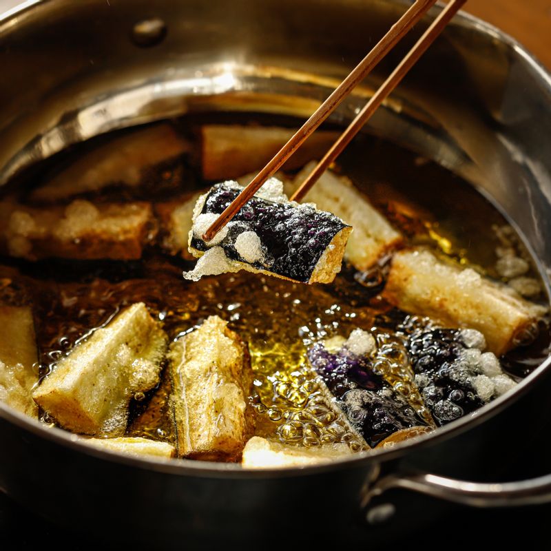 170도로 예열된 기름에 가지를 넣어 바삭하게 튀겨낸 후 채반에 펼쳐 한 김 식혀주세요.