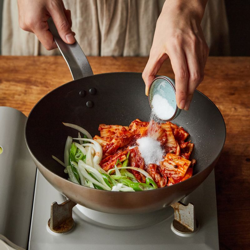 달군 팬에 기름을 두른 후 양파, 대파, 김치, 설탕을 넣어 3분 정도 볶다가 나머지 양념 재료를 넣어 볶아주세요.