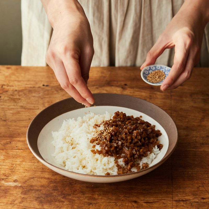 밥에 잘게 썬 우엉과 통깨, 소금, 참기름을 넣고 가볍게 섞어주세요. 밥을 한입 크기로 뭉쳐주세요.