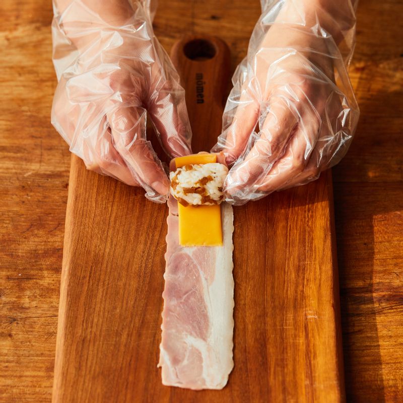 베이컨에 체다치즈와 밥을 넣고 돌돌 말아주세요.