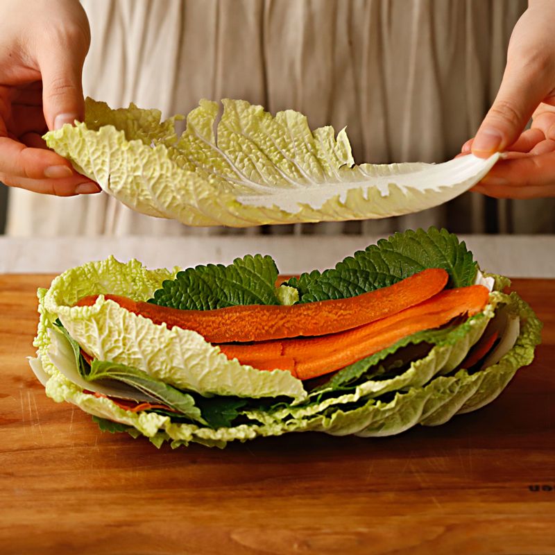 깨끗이 씻은 배춧잎과 깻잎을 겹친 후 얇게 슬라이스한 당근을 올려주세요.
4~5회 반복해서 쌓은 후 4등분 해주세요.
(tip. 사용할 전골냄비 높이에 맞춰서 잘라주세요)