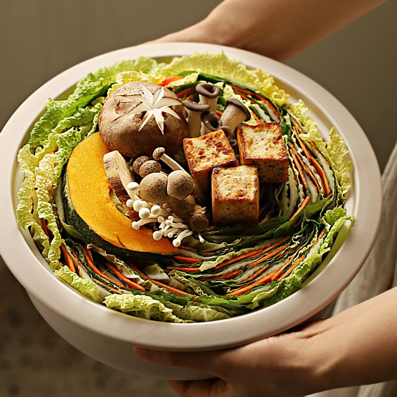 전골 냄비에 청경채를 깔고 겹친 채소를 가지런히 둘러 담아주세요.