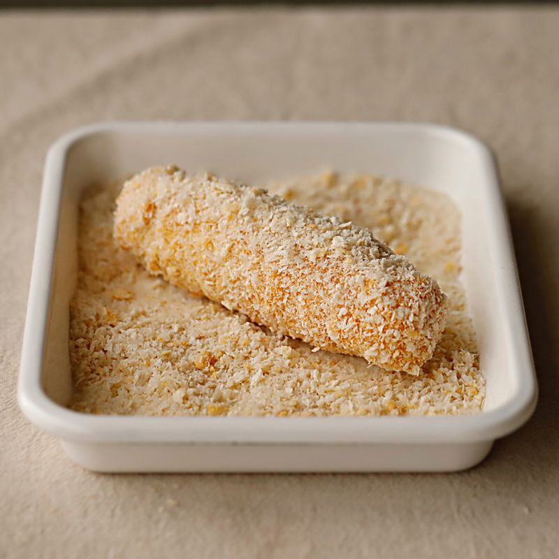 돌돌 말은 식빵에 남은 달걀물을 묻힌 후 빵가루를 묻혀주세요.
(빵가루가 떨어지지 않도록 꾹꾹 눌러 빵가루를 묻혀주세요)
(달걀 물 - 빵가루를 반복해서 2번 정도 묻혀주면 더욱더 도톰한 핫도그를 만들 수 있어요)