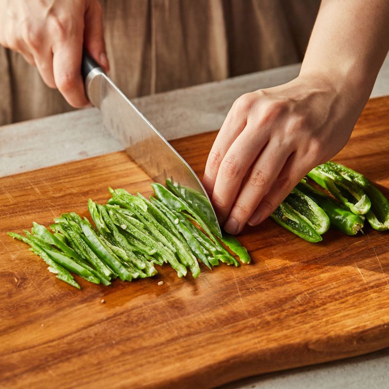 청양고추 8개는 씨를 뺀 후 길게 채를 썰어주세요. 4개는 송송 썰어주세요. 깻잎은 채를 썰어주세요. 스팸은 1cm 두께로 길게 썰어주세요.