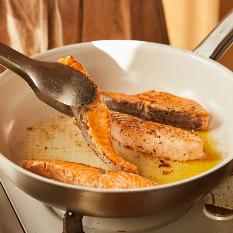 달군 팬에 올리브오일을 두른 후 연어를 넣고 양쪽 면을 3분씩 익혀주세요. 구워진 연어는 접시에 덜어주세요.