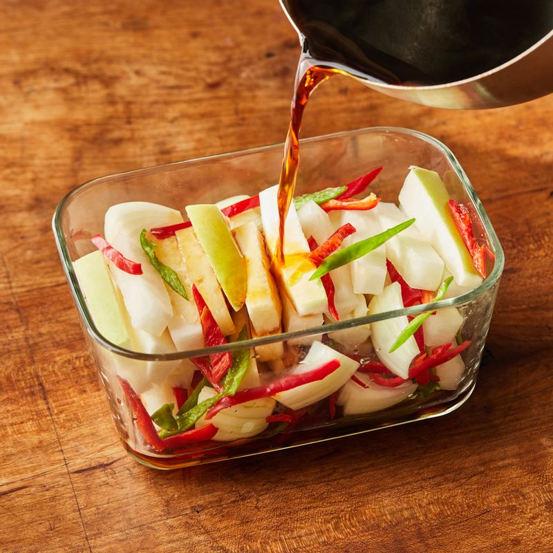 보관 용기에 썰어둔 무와 양파, 고추를 넣고 팔팔 끓인 절임물 재료를 뜨거울 때 붓고 실온에 반나절 두었다가 냉장 보관해 맛있게 즐겨주세요.